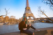 © SASITHORN - Hipster young woman with green hair and red sunglasses which enjoy her vacation in Paris with Eiffel Towe