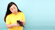 © Justinboat29 - A close-up portrait of a shocked, surprised speechless Woman asia, holding an empty wallet on blue background in studio With copy space.
