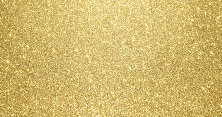 Wall Mural - Gold glitter background with sparkling texture. Golden shimmering light, stars sequins sparks and glittering glow foil background