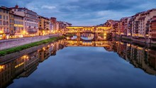 Looping Cinemagraph - Ponte Vecchio Bridge In Florence, Italy Is Illuminated As Night Falls, Logos Blurred For Commercial Use