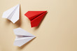 Flat lay of white paper airplanes and red paper airplane on background. Not like that. Individuality. Leader.