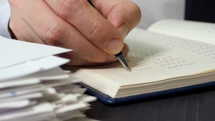 Poster - The accountant writes numbers to the ledger. Stack of papers and paperwork.