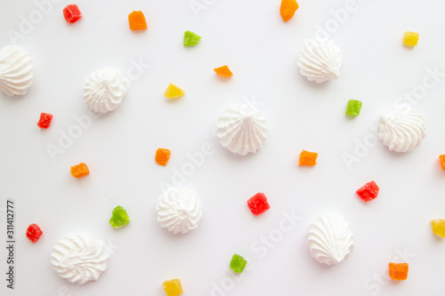 Cuadros en Lienzo White meringue cookies with colorful candied fruits on white background