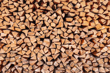 Dry Chopped Wood Stacked In A Woodpile, As A Background