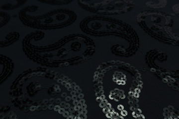 Beautiful closeup of black fabric with plastic decoration and textile texture background