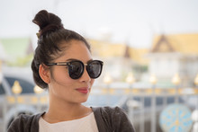 Portrait Of A Beautiful Young Asian Woman Wearing Sunglasses In The Park With Bokeh Background