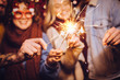 © minastefanovic - Close view of sparklers. Group of happy friends celebrating New Year with sparklers. New year party.
