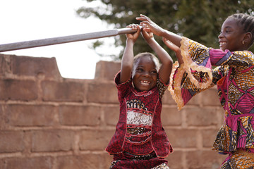 Two Little African Girls Playing At the Water Pump