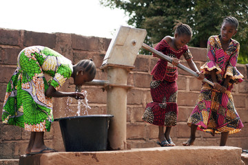 african children at a public borehole fetching water for their families
