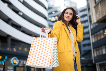 Poster - Beautiful smiling young woman with shopping bags