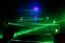 many green lasers bounce off walls along the way