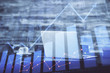 © peshkova - Stock market chart hologram drawn on personal computer background. Multi exposure. Concept of investment.