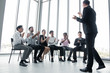 © P Stock - Caucasian young man offering information to people on the team in meeting.