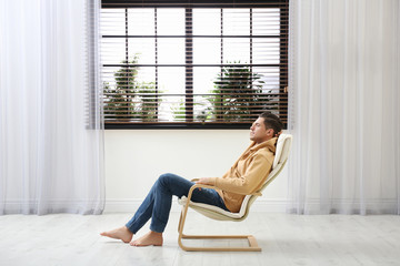 Sticker - Attractive man relaxing in armchair near window at home