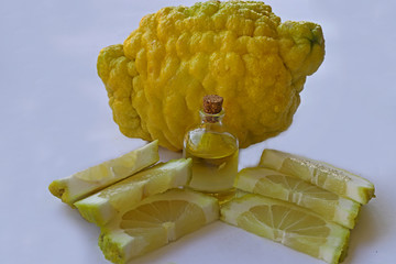 Bergamot oil in bottle and bargamuts on white background