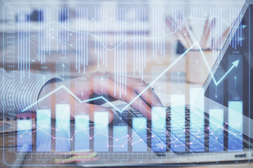 Double exposure of stock market graph with man working on laptop on background. Concept of financial analysis.