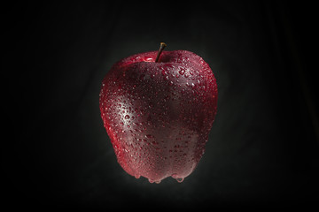 A red apple on a black background.