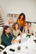 © Seventyfour - Group of five stylish sucessful women working together on new business project using laptop vertical shot