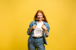 © master1305 - New Year's look. Caucasian woman's portrait on yellow studio background. Beautiful female red hair model in jeanse. Concept of human emotions, facial expression, sales, ad, winter mood, Christmas.