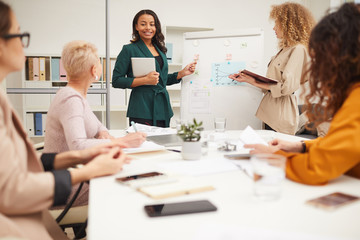 Wall Mural - Two charming women making presentation together at businessmeeting in modern office room