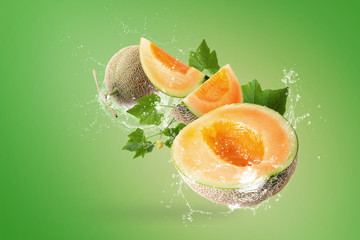 Wall Mural - Water splashing on Sliced of Japanese melons on green background