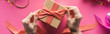 partial view of woman decorating gift box with ribbon on pink background, panoramic shot