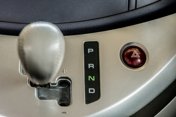 Focus on the letter P R N D tell the gear position and emergency light swith  which is beside the gear shift lever .