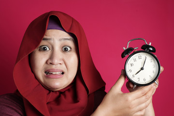 Wall Mural - Muslim Woman Late and Worried Looking at Clock