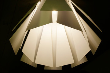 Poster - Metal panels of lamp or lampshade in retro style resembling structure or architectural surfaces. Abstract modern interior background with irregular geometric pattern of glowing elements.
