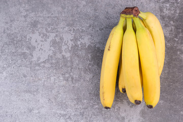 Ripe yellow bananas on a grey structured background,empty  copy space