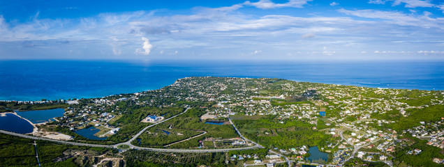 aerial drone footage of the island of grand cayman in the cayman islands in the clear blue and green tropical waters of the caribbean sea