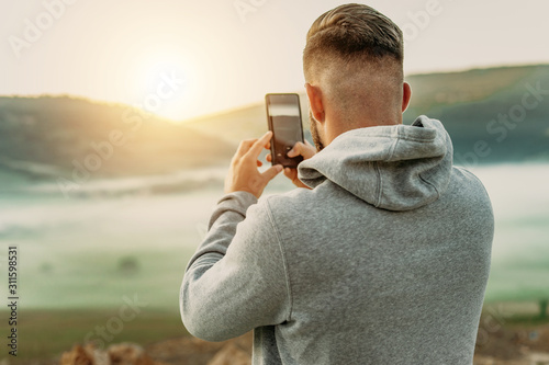 Fotomural Man making selfie on top of mountain