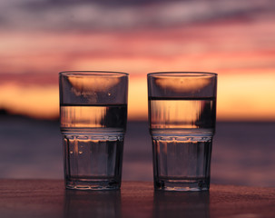 2 glasses of water at sunset on the sea