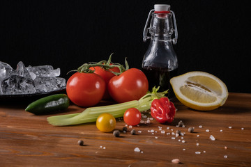 Fresh organic tomato juice decorated with raw tomatoes, leaves on a dark rustic wooden background. Healthy diet nutrition concept. 