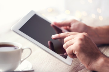 Wall Mural - Male hands holding and using tablet computer