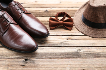 Poster - Male leather shoes with hat and bow tie on brown background