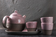 Vintage Handmade Teapot And Cups On The Gray Background, Artwork Concept With Copy Space, Pink Color Of Decorative Ceramic For The Interior