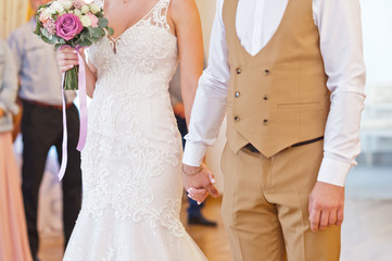 The newlyweds hold hands tightly at the wedding ceremony 2215.