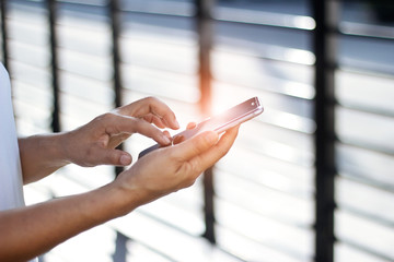 Close up of a woman using mobile smart phone in the morning.