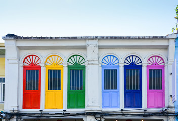 colorful wooden arched window on white cement wall in chino Portuguese style at Phuket old town, Thailand.