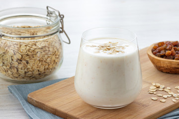 Wall Mural - Vegan oatmeal smoothie with banana in glass jar on the light background. Healthy food.