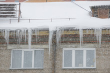 Snow And Icicles Hang From The Roof