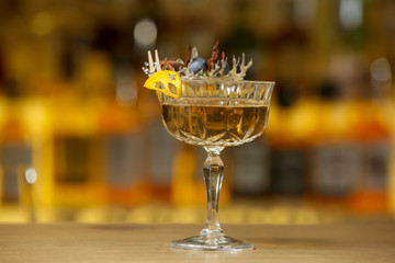 Wall Mural - A glass of beautifully decorated whiskey cocktail with an orange peel on the bar counter