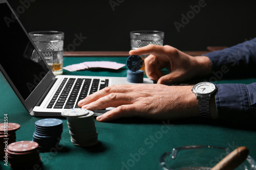 Fotografía Mature businessman playing poker online, closeup