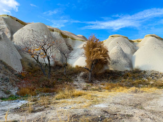 Wall Mural - View of a valley filled with ancient rock formations. Blue sky, white clouds. Landscape. Cappadocia, Turkey. 5 november 2019