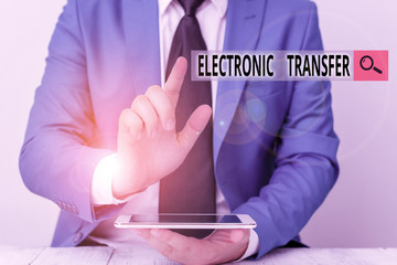 Conceptual hand writing showing Electronic Transfer. Concept meaning transaction that takes place over a computerized network Businessman with pointing finger in front of him