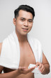 © makistock - Happy man applying lotion after shave on face over white background
