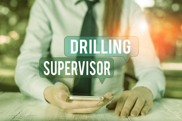 Poster - Word writing text Drilling Supervisor. Business photo showcasing in charge of commercial oil drilling work and process Female business person sitting by table and holding mobile phone