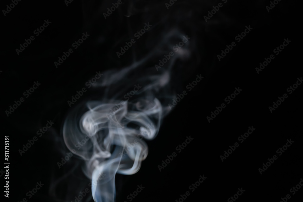 Abstract smoke background with copy space on black background. Blue-white smoke rising from the incense stick
