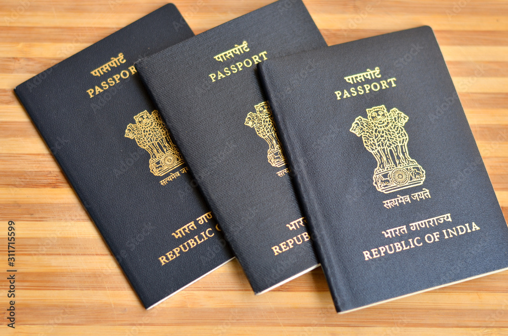 Multiple Indian Passports kept against wooden background on display. The  national emblem of Republic of India is the Lion Capital of Ashoka from  Sarnath is embossed on the passport. Global citizen Stock-bilde |